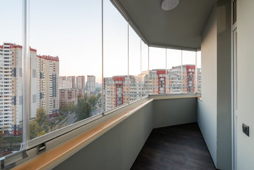 About A modern balcony with glass panels overlooking a city